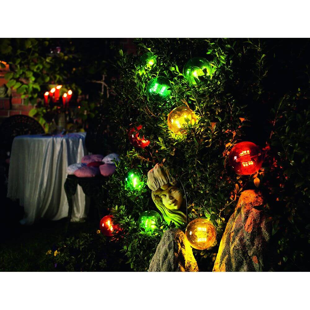 LED Biergartenkette 10er bunt 80 Warmweiße Dioden 24V auf einem hübschen Gartenbaum bei Nacht.