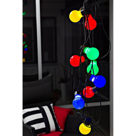 LED Biergartenkette 20er bunt milchig 160 Warmweiße Dioden 24V mit bunte Birnen in einer Atmosphäre bei Nacht.