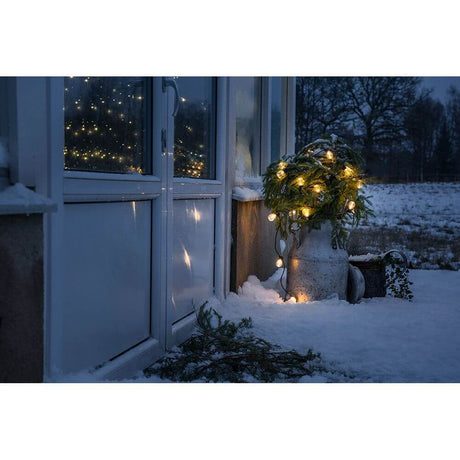 LED Biergartenkette 40er klar 80 bernsteinfarbene Dioden 24V erleuchtet schneebedeckten Garten bei Nacht.
