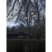 LED Lichtervorhang 10 klare Birnen 80 bernsteinfarbene Dioden IP44 hängend an Bäumen im Garten.