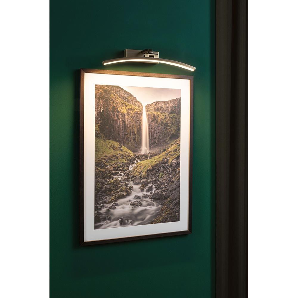 LED Bilderleuchte Bento in Altmessing über einem Landschaftsbild, effektvolle Ausleuchtung in modernem Design.