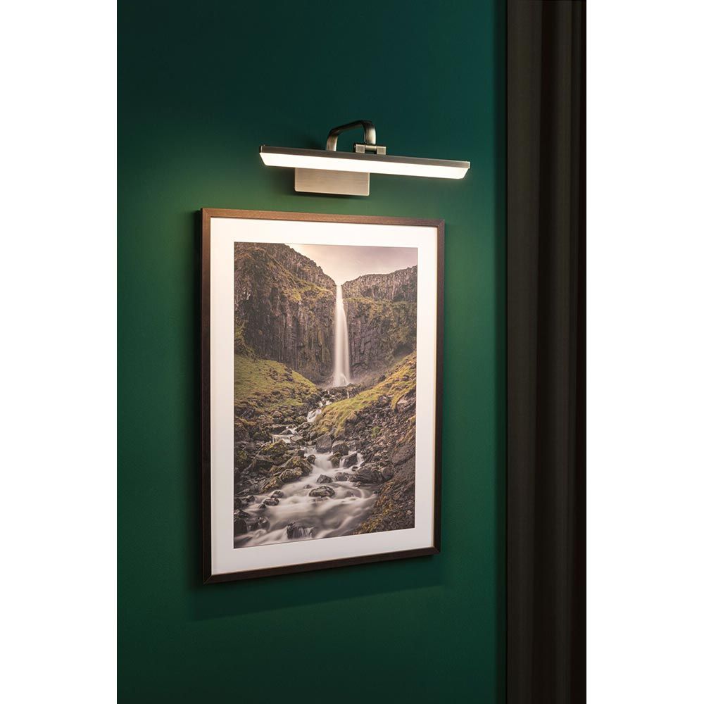 LED Bilderleuchte Renan in Altmessing installiert über einem Landschaftsbild, moderne Wandbeleuchtung für Kunstwerke.