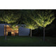 Beleuchteter Garten mit Bäumen und moderner Architektur bei Nacht, die Bodeneinbauleuchten setzen Lichtakzente.