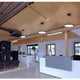 Moderne Büroeinrichtung mit LED Ring-Hängeleuchten, Holzdecke und schickem Empfangstresen.