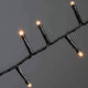 LED Büschellichterkette Cluster Schwarz mit leuchtenden Lichtern auf schwarzem Kabel.