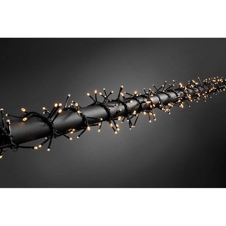 LED Büschelllichterkette Cluster Multifunkiton 240 Warmweiße Dioden batteriebetrieb IP44 an schwarzem Hintergrund.