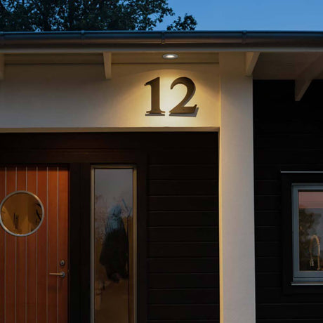 LED Downlight encastré extérieur pour plafond IP44 éclaire le numéro 12 sur une façade moderne.