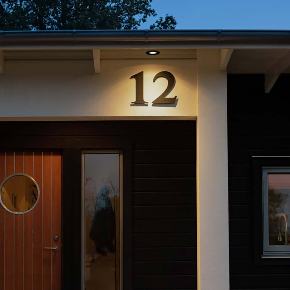 LED Aussen-Deckeneinbau Downlight IP44 beleuchtet die Hausnummer 12 an einem modernen Eingang.