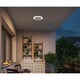 Moderne LED Außen Wand- & Deckenleuchte Circula in einem gemütlichen Außenbereich bei Nacht.