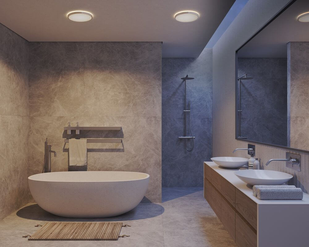 LED Deckenleuchte Oja 42 3-Stufen IP54 in modernem Badezimmer mit freistehender Badewanne und eleganten Waschbecken.