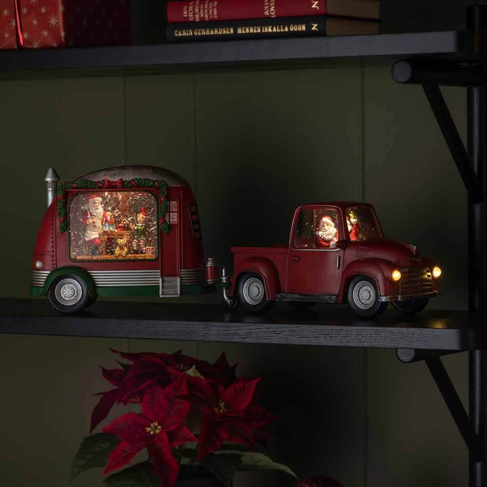 LED Dekoleuchte Pick-up mit Weihnachtsmann batteriebetrieben Rot auf Regal, leuchtende Weihnachtsdeko mit Anhänger und Weihnachtsmann im Fahrerhaus