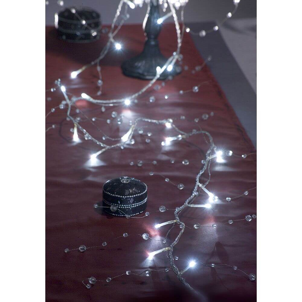 LED Dekolichterkette Acryl Perlen 32 Kaltweiße Dioden auf festlich gedecktem Tisch mit Glanz und Eleganz.