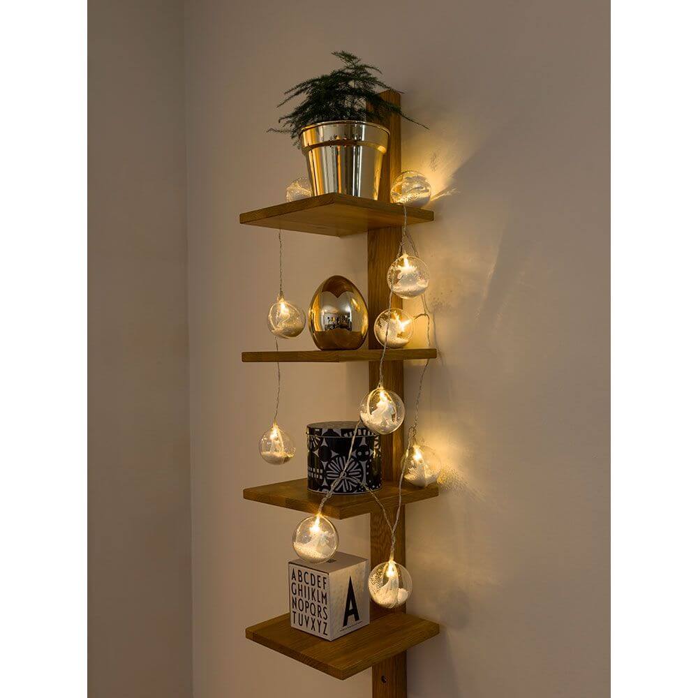 LED Dekolichterkette Acrylkugel Weihnachtsbaum Schnee 10 Warmweiße Dioden batteriebetrieb auf einem Holzregal mit Pflanzen.