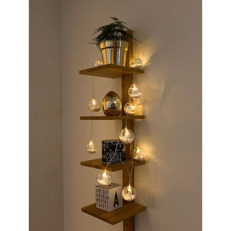LED Dekolichterkette Acrylkugel Weihnachtsbaum Schnee 10 Warmweiße Dioden batteriebetrieb auf einem Holzregal mit Pflanzen.