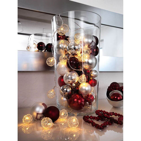 LED decorative light chain aluminum wire balls small 16 warm white diodes battery-operated in a glass container with Christmas balls.