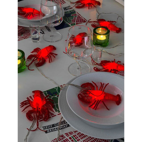 LED Dekolichterkette Krebse 8 Warmweiße Dioden auf festlich gedecktem Tisch mit Gläsern und Kerzen.