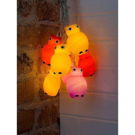 LED Dekolichterkette bunte Eulen 16 Warmweiße Dioden an einer Wand mit einer warmen Lichtatmosphäre.
