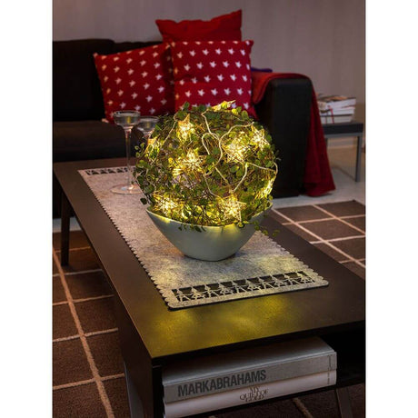 LED Decorative string lights gold-colored metal stars 16 warm white diodes in a decorative bowl on a coffee table.
