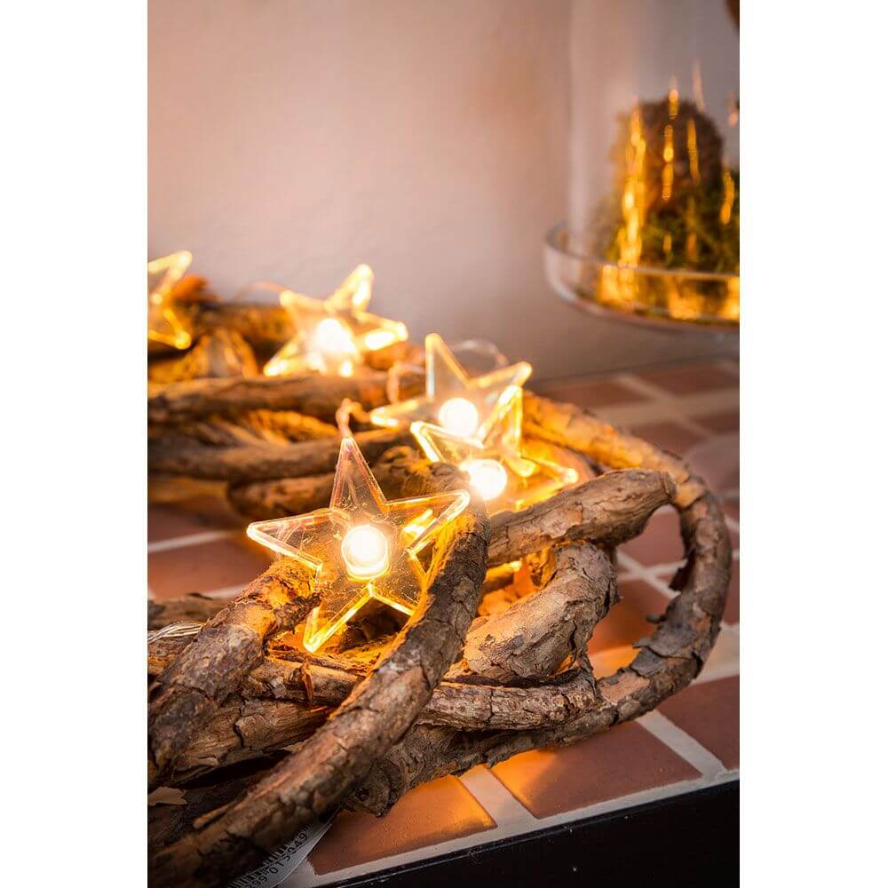LED Dekolichterkette klare Sterne 10 Warmweiße Dioden batteriebetrieben auf einem Holzkranz mit warmem Licht.