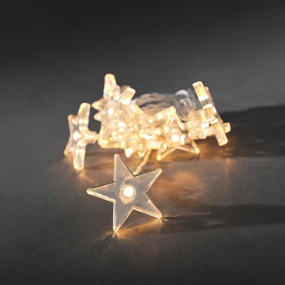 LED Dekolichterkette klare Sterne 10 Warmweiße Dioden batteriebetrieben, funkelnde Sterne auf dunklem Hintergrund.