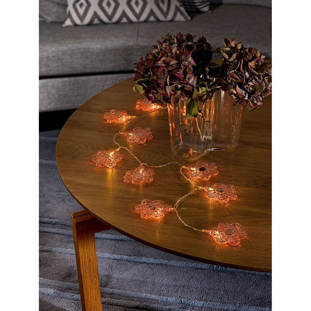 LED Dekolichterkette kupferfarbene Metallblumen 10 Warmweiße Dioden batteriebetrieben auf einem Holztisch mit Blumen