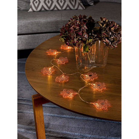 LED decorative string lights copper-colored metal flowers 10 warm white diodes battery-operated on a wooden table with flowers