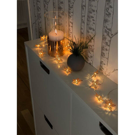 LED Dekolichterkette kupferfarbene Metallsterne 20 Warmweiße Dioden batteriebetrieben auf einem Tisch drapiert.
