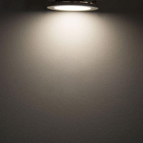 LED innfelt panel Ø 15 cm, flatt, rundt, sølvfarget, dimbart 9 W nøytralhvit lyser mot en vegg.