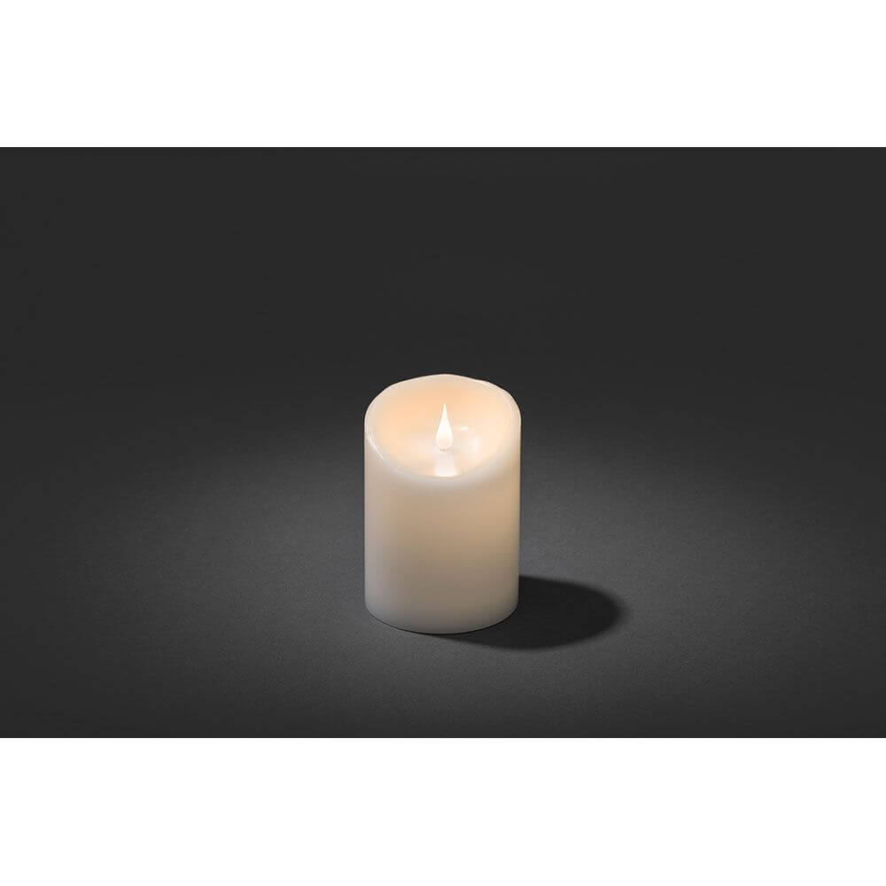 LED Echtwachskerze weiß mit 3D Flamme 14cm Timer Warmweiß batteriebetrieb auf dunklem Hintergrund.