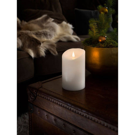 Hvit LED-ekte vokslys med 3D-flamme 16 cm, timer, varmhvit, batteridrevet på et trebord i et koselig rom.