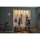 Wand mit integrierter Beleuchtung, Garderobe, Holzregal, Fahrrad und farbenfrohem Teppich in modernem Wohnzimmer.