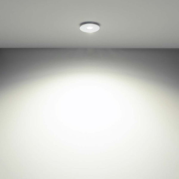 LED-Luminaire encastrée Tet sans lentille au plafond, avec une lumière douce sur un mur neutre.