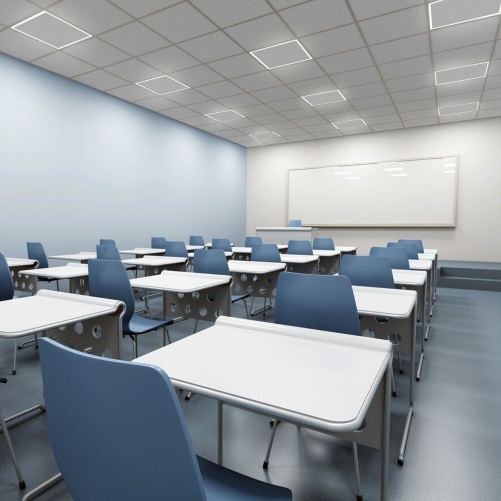 Moderne Klassenraum mit LED Einlegerahmen und Schreibtischen in blauer Farbgestaltung.