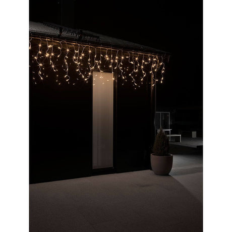 LED Eisregen Lichtervorhang 200 bernsteinfarbene Dioden IP44 an einem Gebäude in der Nacht.