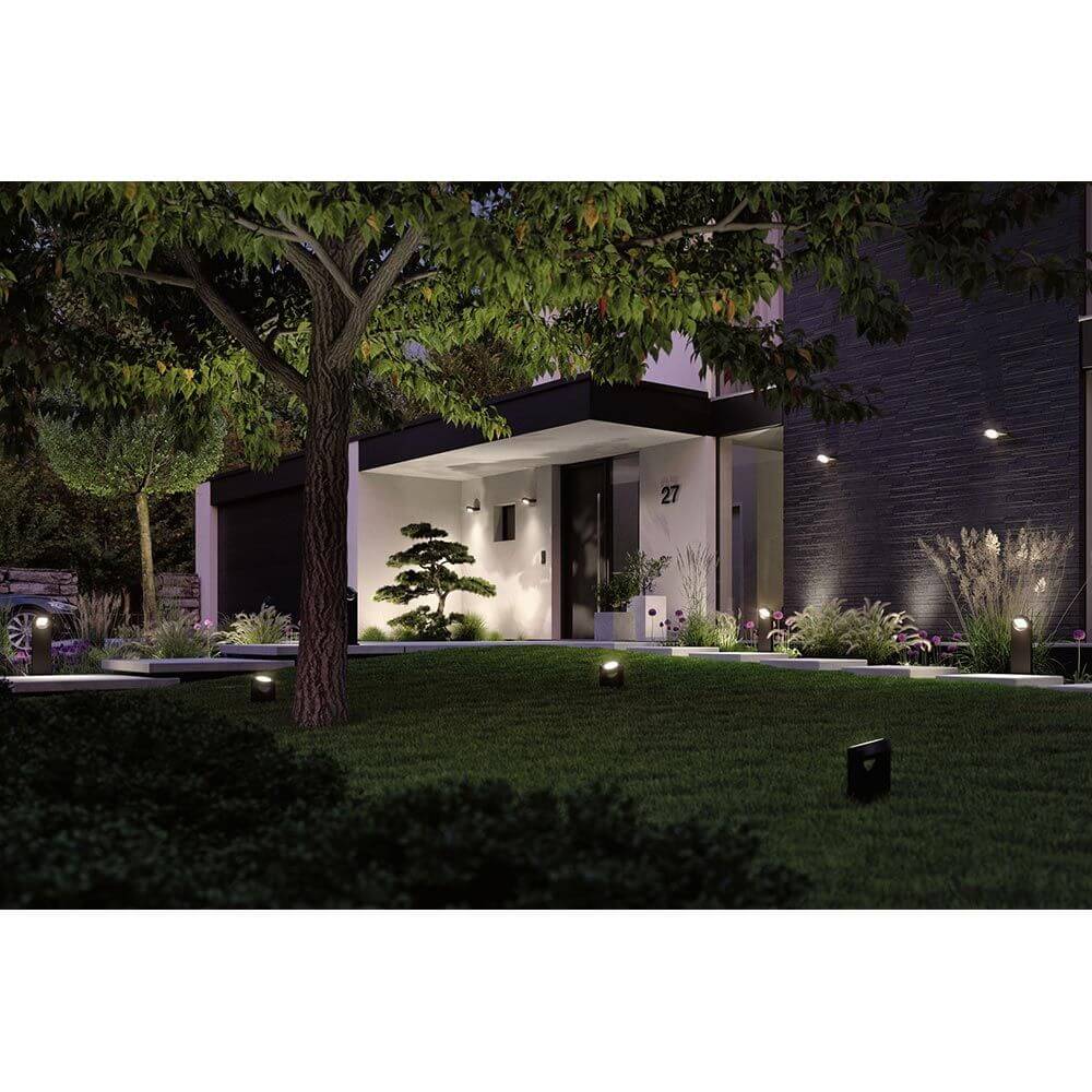 LED Gartenstrahler Swivea beleuchtet den Garten und die Fassade bei Nacht in warmweißem Licht.