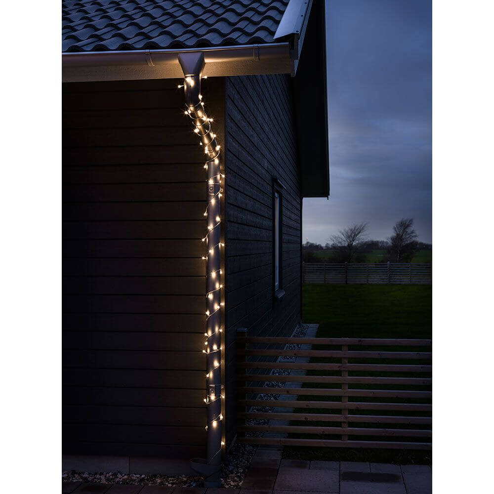 LED Globelichterkette runde Dioden 160 Warmweiße Dioden IP44 dekoriert eine Hauswand bei Nacht.