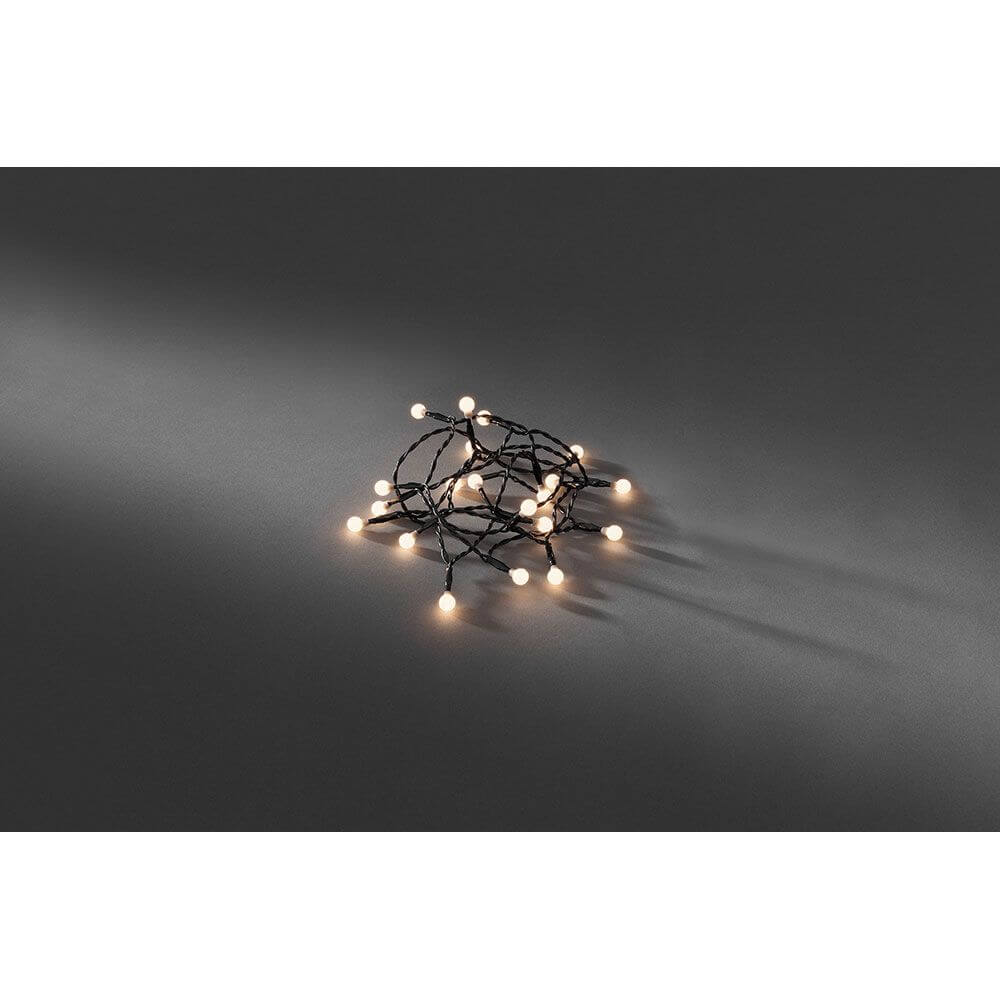 LED Globelichterkette 50 runde Dioden Warmweiß batteriebetrieben auf dunklem Untergrund.