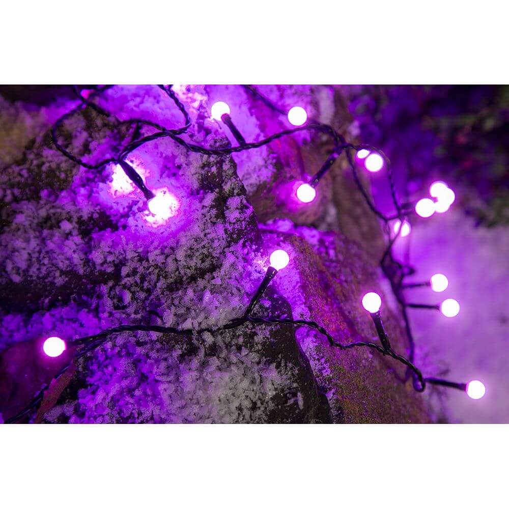 LED Globelichterkette runde Dioden 80 purpurfarbene Dioden IP44 auf schneebedecktem Boden.