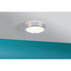 LED HomeSpa Panel Aviar Ø 22cm CCT-Steuerung Weiß, Chrom an der Decke montiert in einem Innenraum mit blauer Wand.