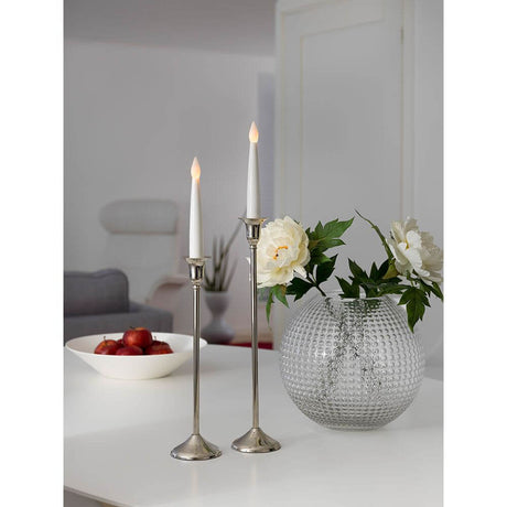 LED-lysestaker 2-pakning hvit, liten, flakkende dioder, varmhvit, batteridrevet på bord med blomster og fruktskål.