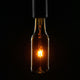 E27 LED Bierflasche Beer Bulb Dimmbar in einem dunklen Hintergrund, originale Bierflasche mit warmem Licht.
