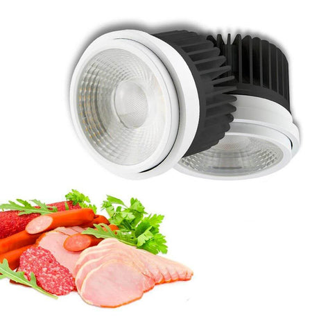 LED pour boucherie orientable 35°-50° 3200K 1853lm 30W avec viande fraîche et saucisses sur une table.