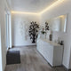 Modernes Wohnzimmer mit LED-Beleuchtung und dekorativen Wandpaneelen in neutralen Tönen.