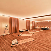 Gemütlicher Raum mit LED-Lichtdecke 26 - 35 m², Matten und stilvollem Dekor für Yoga und Entspannung.