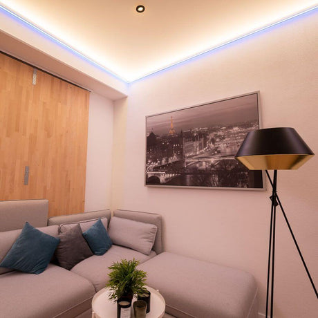 LED-Lichtdecke Spannfolie 10 - 15 m² in modernem Wohnbereich mit stilvollem Sofa und Beleuchtung.