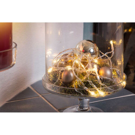 LED Lichterkette 10 Warmweiße Dioden batteriebetrieben in einer Glasvase mit Weihnachtsdecor und glitzernden Kugeln.