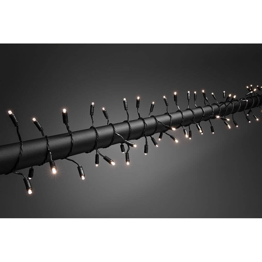 LED Lichterkette mit Lauflicht und verlängertem Steg: 4cm 120 Warmweiße Dioden IP44 auf dunklem Hintergrund.