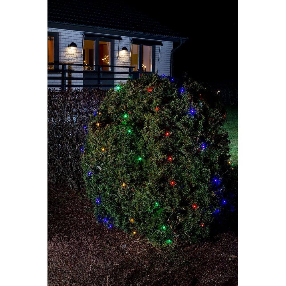 LED Lichternetz 64 bunte Dioden IP44 auf einem Strauch im Garten bei Nacht.
