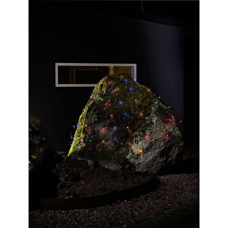 LED Lichternetz mit bunten Globes 80 bunte Dioden IP44 auf einem großen Stein im Garten bei Nacht.