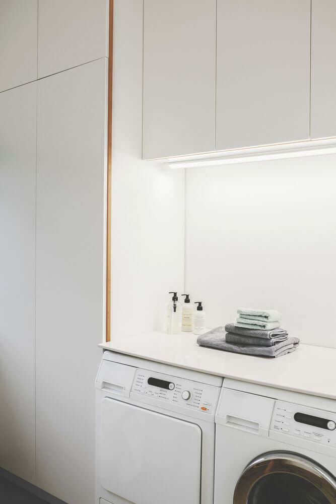LED Lichtleiste Glendale 120 beleuchtet eine moderne Waschküche mit Waschmaschinen und frischen Handtüchern.